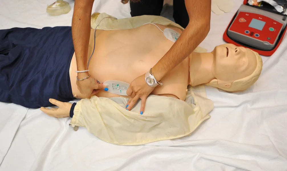 Teilnehmende üben den Einsatz eines Defibrillators