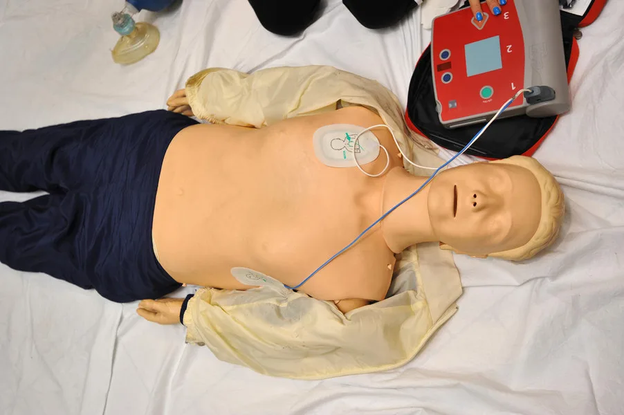 Anwendung eines Defibrillators an einer Übungspuppe